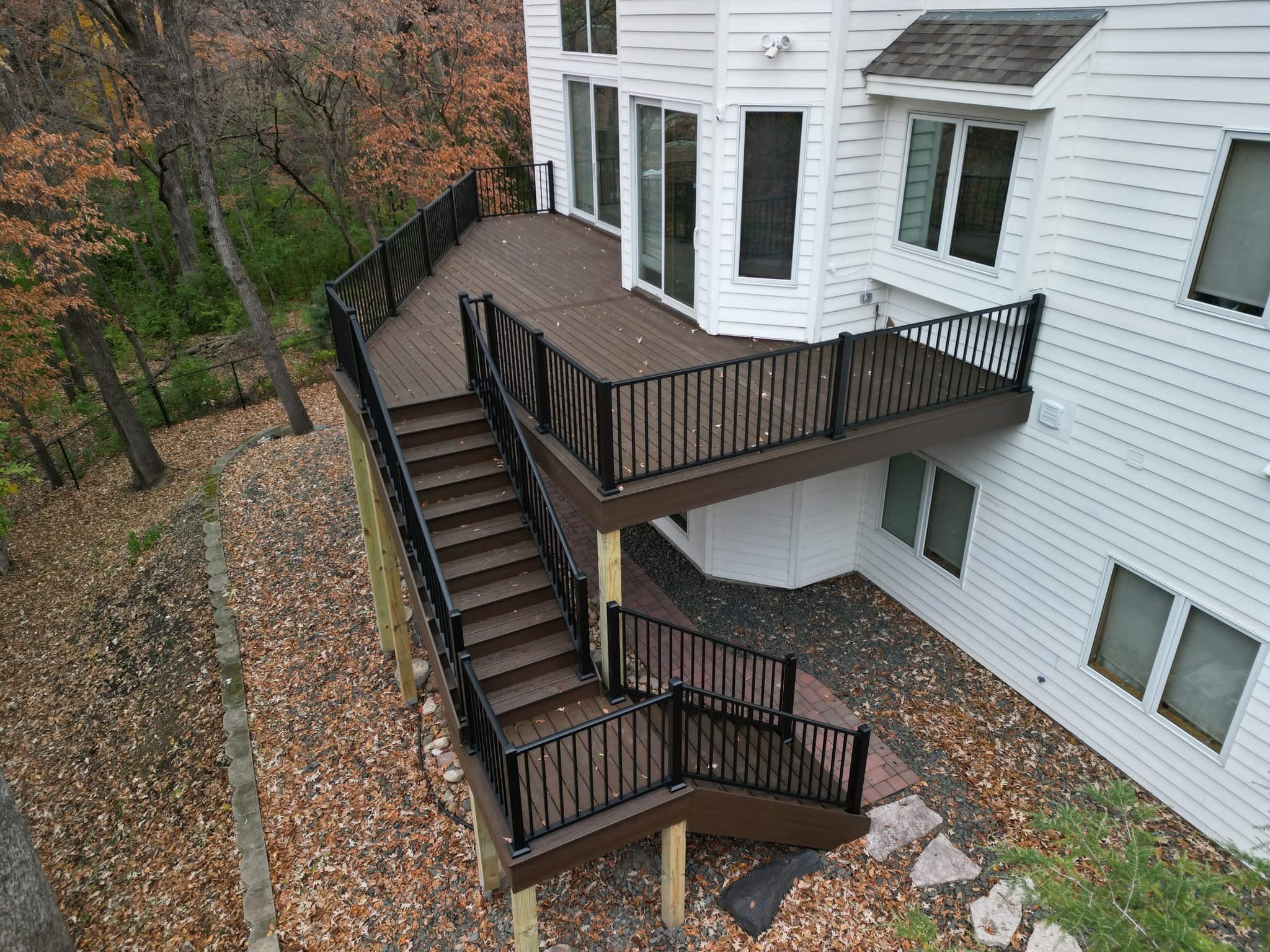 Hillside deck with switchback stairs among fall foliage